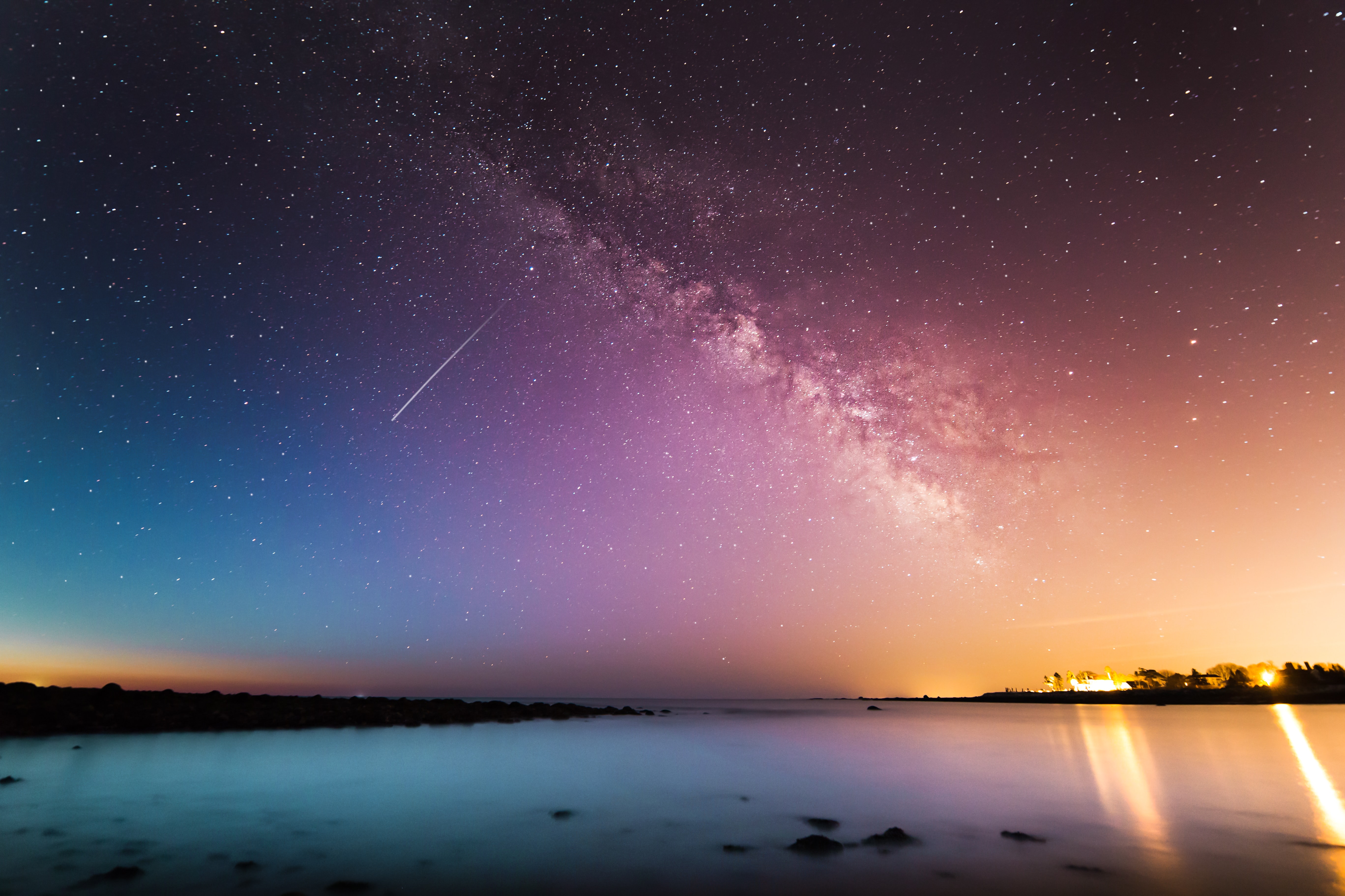 A shooting star and the milkyway seen at sunset above a lake