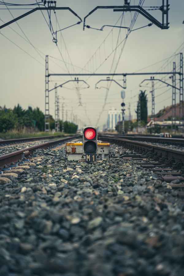 A red stoplight activated along train tracks.